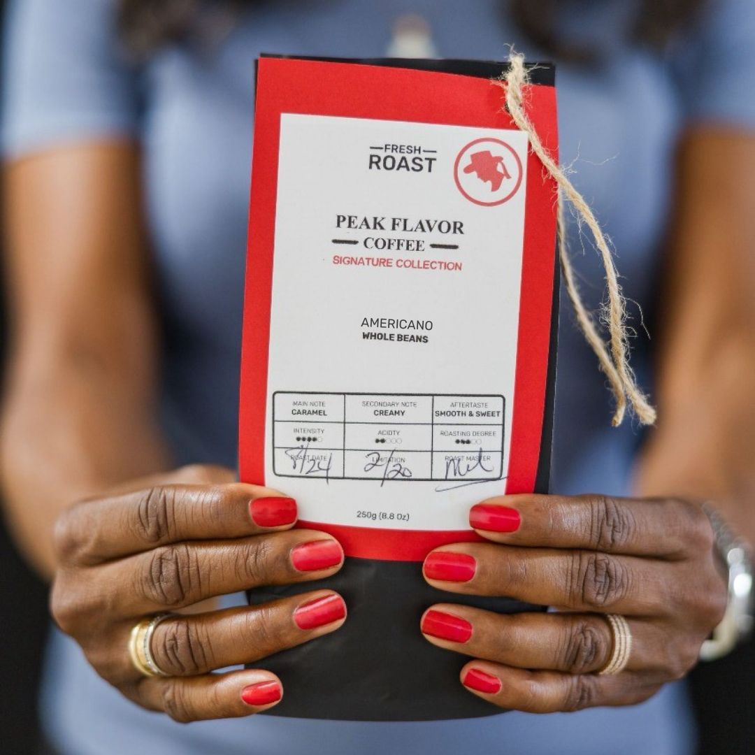 Melicent holds a Peak Flavor Coffee bag with americano coffee beans