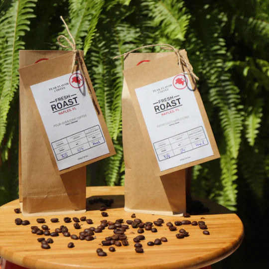 Two bags of freshly roasted Peak Flavor Coffee on a small table